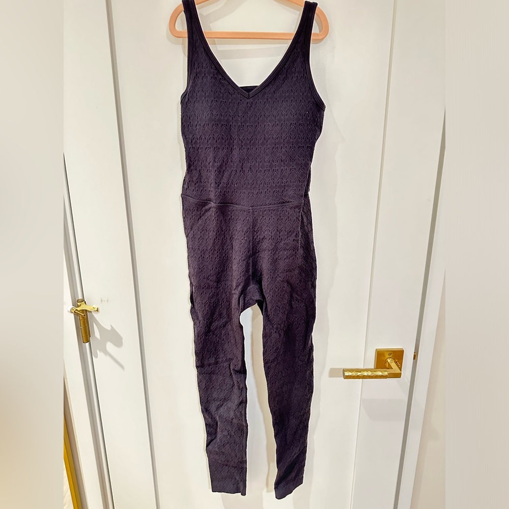 Black bodysuit with textured fabric, built-in bra and open back detail. Size XS